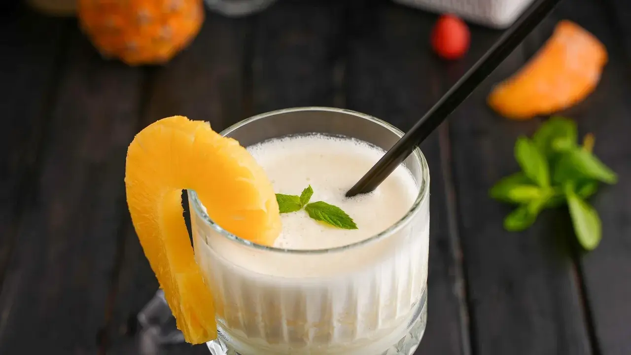 En krämig pina colada med ananasskiva och mynta. Perfekt för ett soligt pina colada recept.