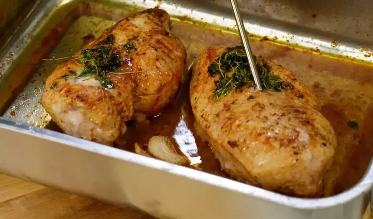 Två saftiga kycklingbröst i en ugnsform, kryddade med örter och vitlök. Perfekt mat med kyckling för en härlig middag.