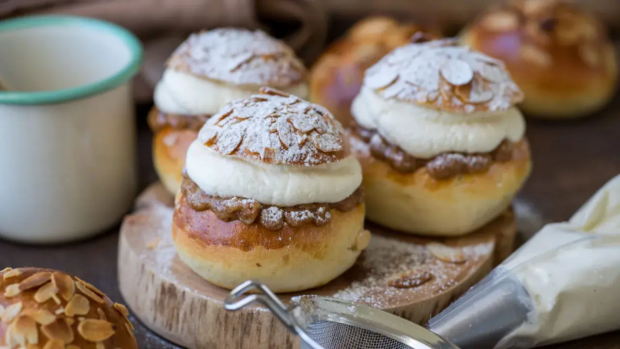 Fredriks fika med semlor recept: fluffiga bullar fyllda med mandelmassa och grädde, pudrade med florsocker och mandelspån.