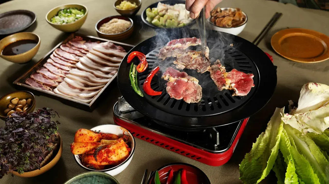Koreansk BBQ med saftigt kött som grillas, serveras med kimchi, vitlök och en hemlagad koreansk bbq sås recept.