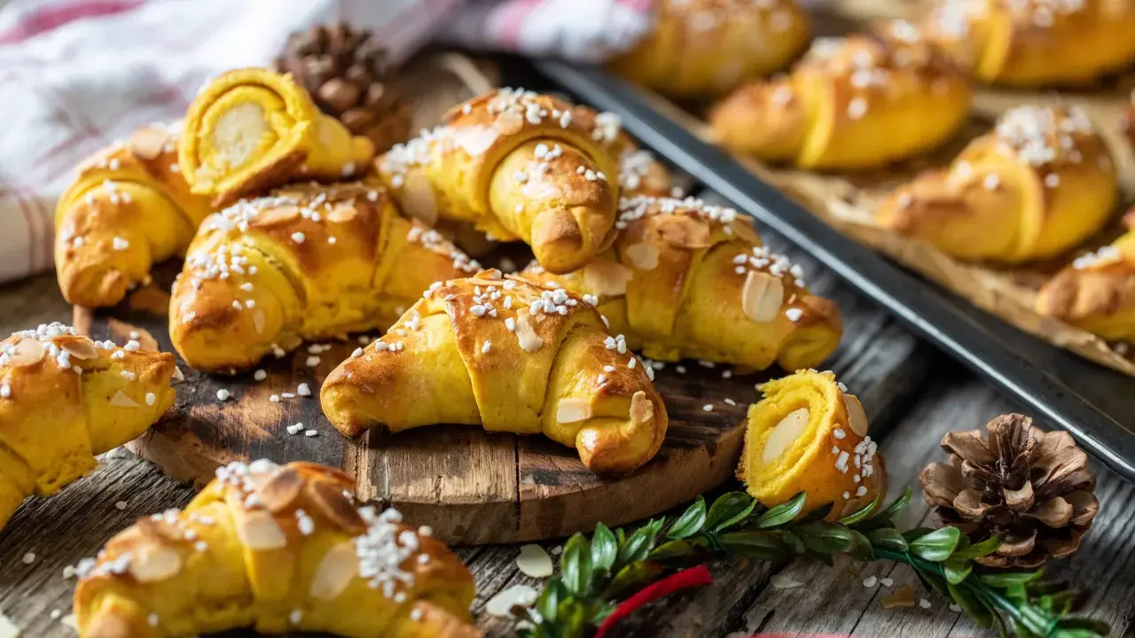 Fredriks fika: gyllene saffransbullar med mandelmassa, toppade med pärlsocker och mandelflagor. En härlig juldoft sprider sig.