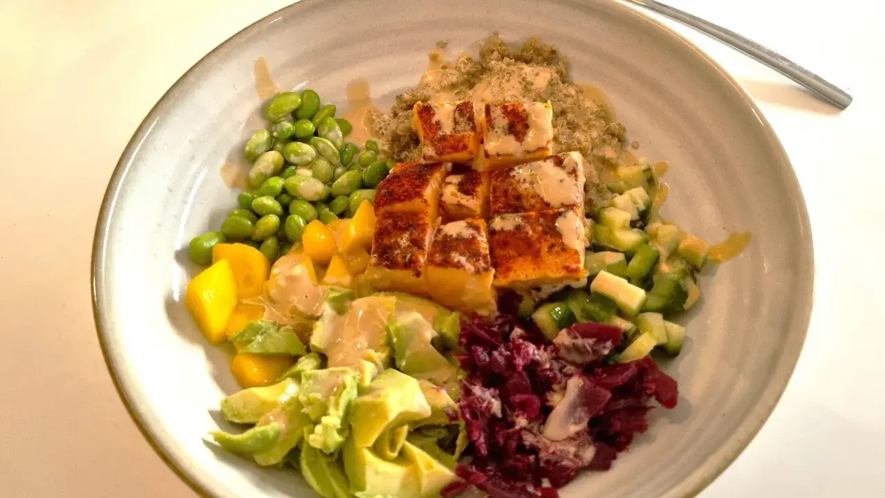 En färgstark bowl med lax, quinoa, edamamebönor, mango, avokado och rödbetor. Perfekt för nyttiga recept!
