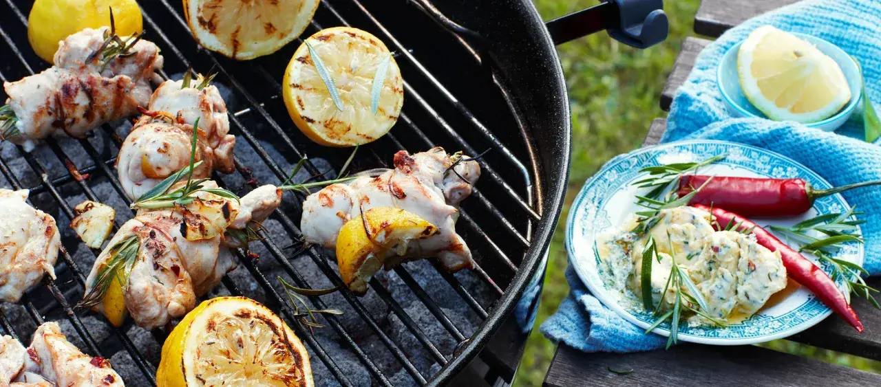 Grillad kyckling med citron och rosmarin, perfekta kryddor till kyckling. En tallrik med krämig röra, chili och örter står bredvid.