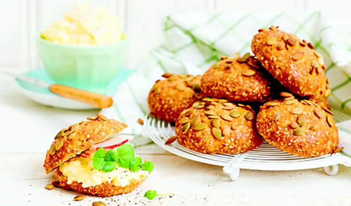 Frukost tips: Nybakade frallor med pumpafrön och sesamfrön, en fylld med äggsallad, skinka och basilika.