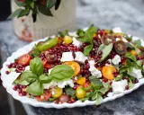 En matig sallad med fetaost, granatäpple, körsbärstomater och färska örter. En festlig och färgstark rätt.