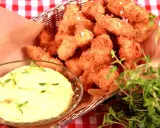 Korg med gyllene chicken nuggets, serverade med en krämig dipp och färska örter.