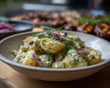 Krämig potatissallad med dill och rödlök, perfekt som tillbehör till grillat.