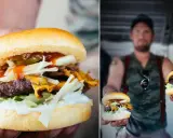 En närbild på en saftig hamburgare med ost, sallad och dressing. Till höger håller en man upp två hamburgare, perfekt för ett hamburgare recept.