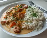 En krämig korv stroganoff med skivad korv, lök och paprika, serverad med fluffigt ris och strödd persilja. En klassisk svensk rätt.