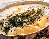 En krämig stuvad potatis med dill, serverad i ett vackert uppläggningsfat.