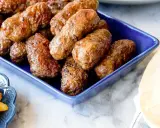 En blå skål fylld med saftiga cevapcici, redo att avnjutas. Ett perfekt cevapcici recept för alla köttälskare.