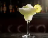 En frostig frozen margarita med saltkant och limeklyfta, perfekt för en varm sommardag.