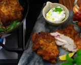 Krispig schnitzel med ost och skinka, serverad med en krämig sås till schnitzel, citron och körsbärstomater.
