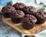 Fluffiga muffins recept: Mörka chokladmuffins med chokladknappar på en träbricka. Perfekta för fikat!