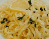 En tallrik med krämig citronpasta, toppad med en citronskiva och färsk persilja. Perfekt för en lätt lunch eller middag.