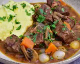 En mustig boeuf bourguignon med möra köttbitar, champinjoner, morötter och små lökar, serverad med krämigt potatismos.