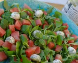 En uppfriskande sallad med vattenmelon, gröna blad och små bollar av ost, perfekt som sallad till paj.