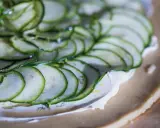 Tunna skivor av zucchini läggs på en krämig fyllning på en pajdeg. En underbart god paj som snart är redo att avnjutas.