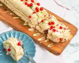 En läcker budapestrulle med hallon och vit choklad, toppad med färska röda vinbär och rivet limeskal.