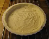 En vit pajform med en färdig glutenfri pajdeg från Lailas. Pajdegen är pressad mot formens kanter och har ett mönster i mitten.