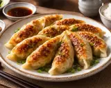 Gyldene, stekpanne-stekte dumplings, pyntet med vårløk. Perfekt for et enkelt dumplings recept. Serveres med dipp og ris.