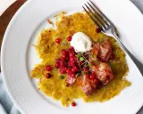 En gyllene råraka med knaperstekt bacon, lingon och en klick gräddfil. Ett klassiskt råraka recept som är perfekt för en helgmåltid.