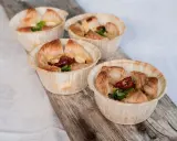 Fyra små, gyllene minipajer i muffinsform, fyllda med ost, soltorkade tomater och grönt. Perfekta som tilltugg.