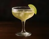 En kyld margarita med saltkant och limeklyfta. Perfekt för ett enkelt margarita recept.