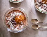 Chokladpudding med kokosflingor och kakaonibs, en perfekt proteinrik frukost. Två skedar ligger bredvid.