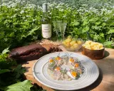 En härlig sommardukning med sill, färskpotatis, mörkt bröd och en flaska Östgöta Sades Brännvin för egen snaps till sillen.