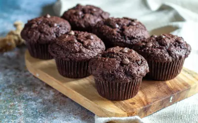 Fluffiga muffins recept: Mörka chokladmuffins med chokladknappar på en träbricka. Perfekta för fikat!
