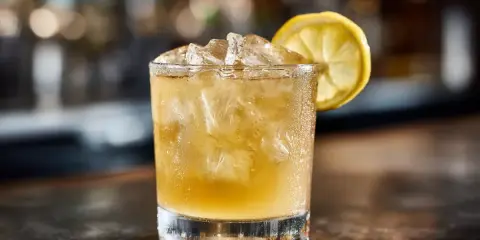 En kyld whiskey sour med is och en citronskiva, redo att avnjutas.