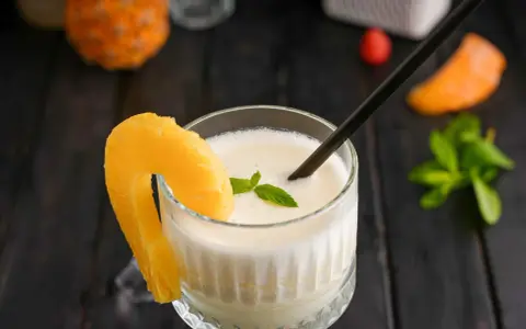 En krämig pina colada med ananasskiva och mynta. Perfekt för ett soligt pina colada recept.