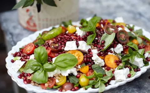 En matig sallad med fetaost, granatäpple, körsbärstomater och färska örter. En festlig och färgstark rätt.