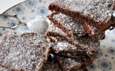 En hög med saftig kladdkaka i långpanna, pudrad med florsocker. Perfekt för fikat!