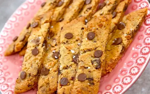 En rosa tallrik fylld med hembakade kolasnittar med choklad. Perfekta för fikat!