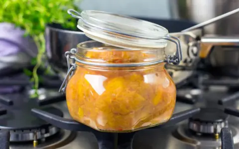 En burk med hemlagad rabarberchutney står på spisen, redo att avnjutas.