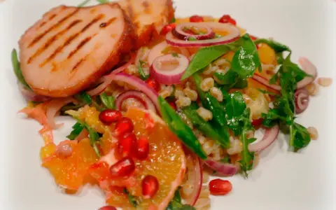 Grillad fläskfilé med en fräsch sallad av apelsin, rödlök, granatäpple och bulgur. Ett härligt sallad recept!