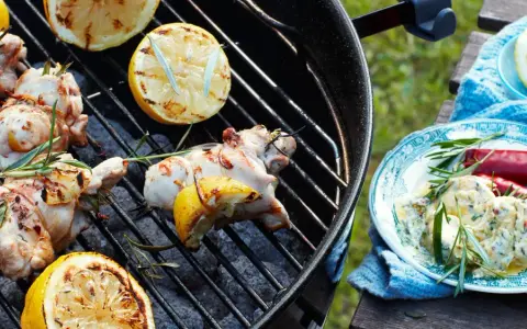 Grillad kyckling med citron och rosmarin, perfekta kryddor till kyckling. En tallrik med krämig röra, chili och örter står bredvid.