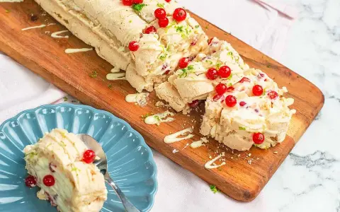 En läcker budapestrulle med hallon och vit choklad, toppad med färska röda vinbär och rivet limeskal.