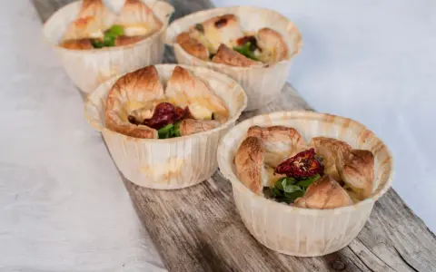 Fyra små, gyllene minipajer i muffinsform, fyllda med ost, soltorkade tomater och grönt. Perfekta som tilltugg.