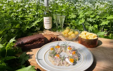 En härlig sommardukning med sill, färskpotatis, mörkt bröd och en flaska Östgöta Sades Brännvin för egen snaps till sillen.