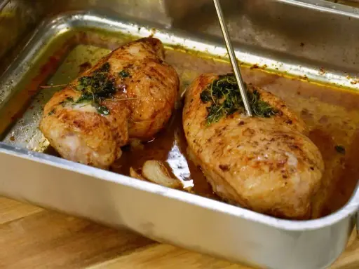 Två saftiga kycklingbröst i en ugnsform, kryddade med örter och vitlök. Perfekt mat med kyckling för en härlig middag.