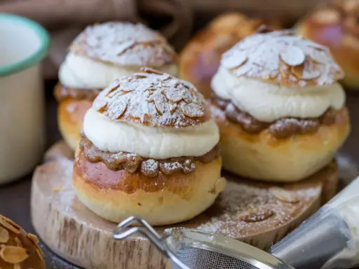 Fredriks fika med semlor recept: fluffiga bullar fyllda med mandelmassa och grädde, pudrade med florsocker och mandelspån.