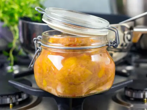 En burk med hemlagad rabarberchutney står på spisen, redo att avnjutas.