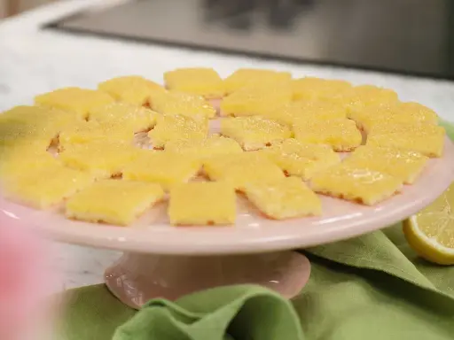 Fredriks fika: Citronrutor på ett rosa tårtfat, redo att avnjutas.