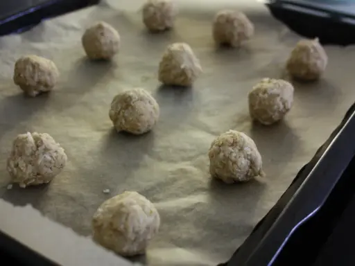 Små, runda havrekakor ligger på ett bakplåtspapper, redo för Fredriks fika.