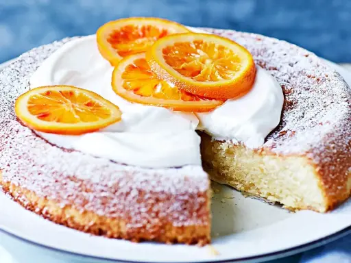 En saftig citron och mandelkaka, pudrad med florsocker och toppad med vispgrädde och apelsinskivor. Perfekt för Fredriks fika!