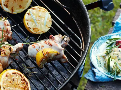 Grillad kyckling med citron och rosmarin, perfekta kryddor till kyckling. En tallrik med krämig röra, chili och örter står bredvid.