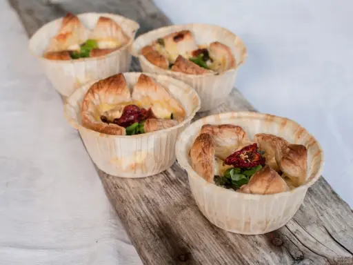Fyra små, gyllene minipajer i muffinsform, fyllda med ost, soltorkade tomater och grönt. Perfekta som tilltugg.